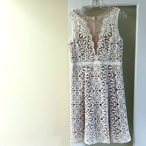 Lace dress with fitted top and flare bottom, white lace with tan underneath.